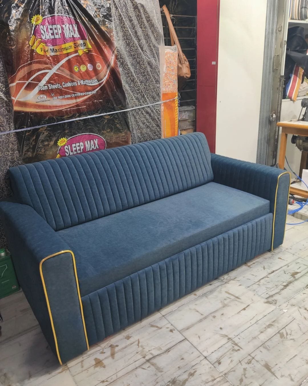 Slate blue textured velvet custom 3-seater sofa cum bed in daytime sofa mode with vertical channeling